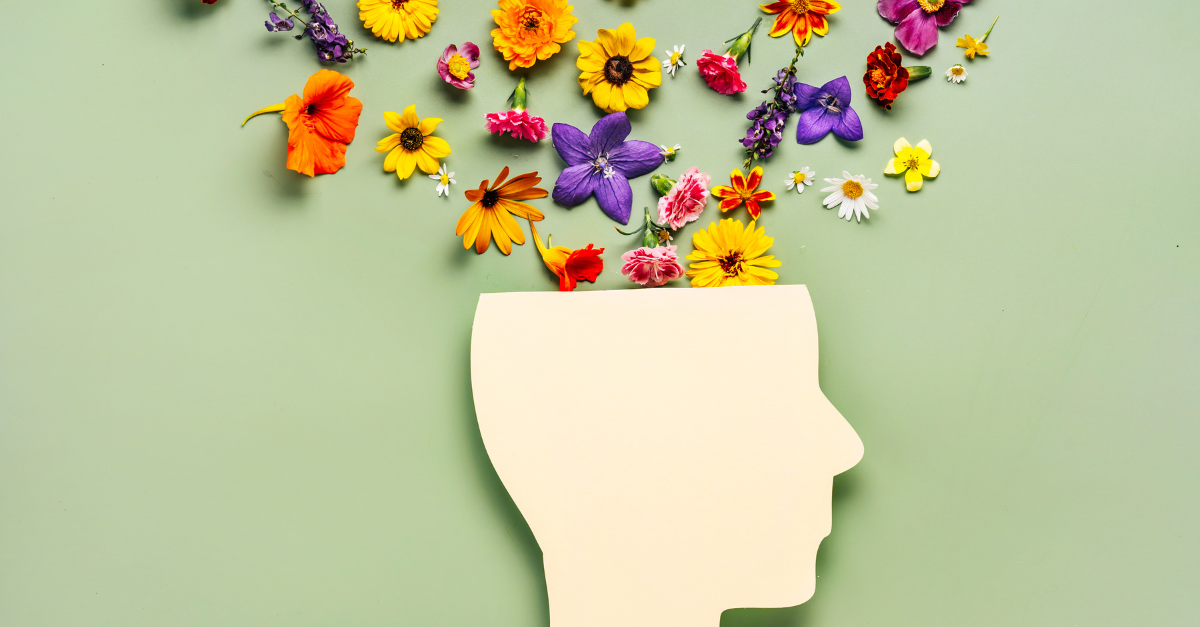 An abstract silhouette of a human head with vibrant flowers emerging from it, symbolizing the importance of mental health during emergencies and the potential for growth and healing.