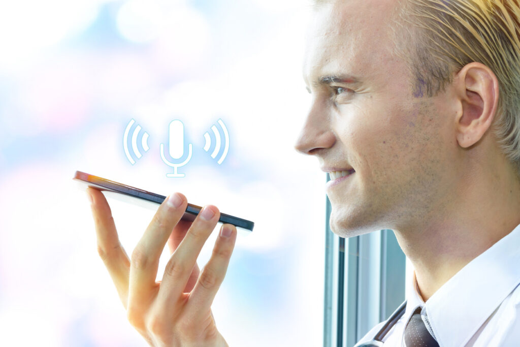 Smiling doctor using phone for ambient scribes.